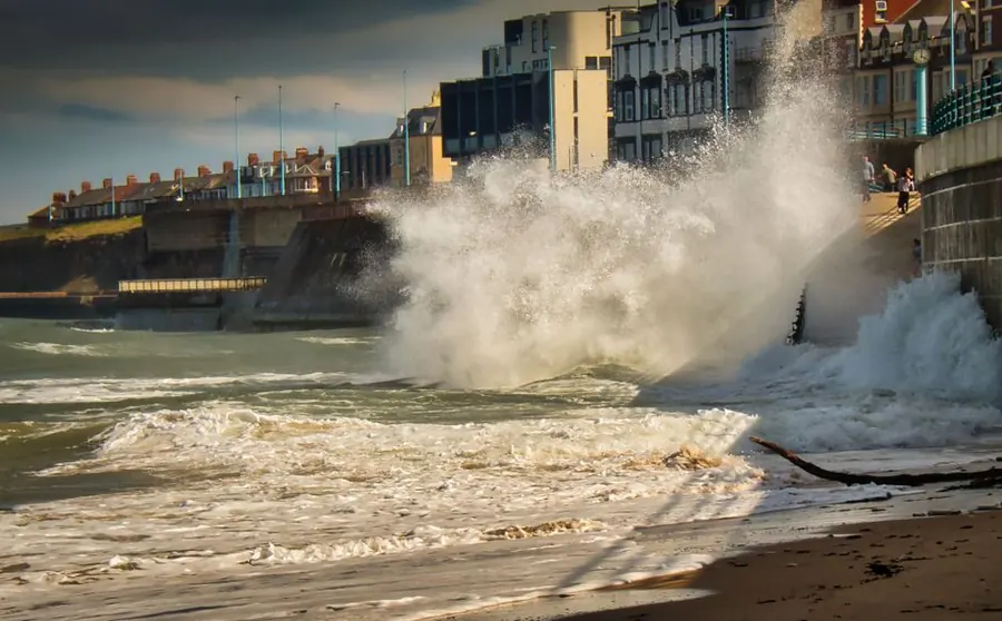 Waves breaking against a seafront during heavy weather, the kind of exposure Weston-super-Mare roofs face each winter