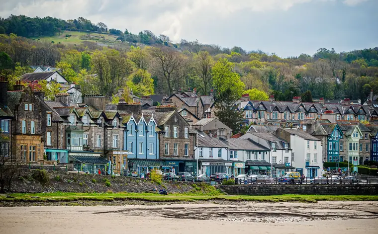 Victorian stone villas and gabled terraces stacked up a wooded hillside above a seafront, the kind of layered period streets found in Clevedon