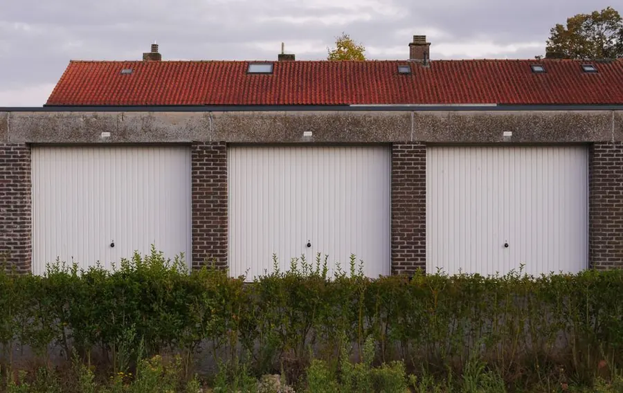 A block of brick garages of the kind commonly built with cold deck flat roofs around Weston-super-Mare