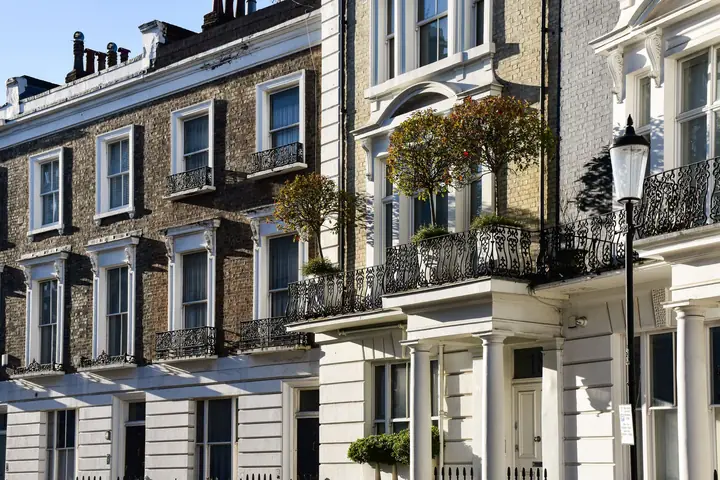 A row of stucco-fronted period townhouses with cast-iron balconies over the ground floor, the kind of street frontage a Clevedon conservation area protects
