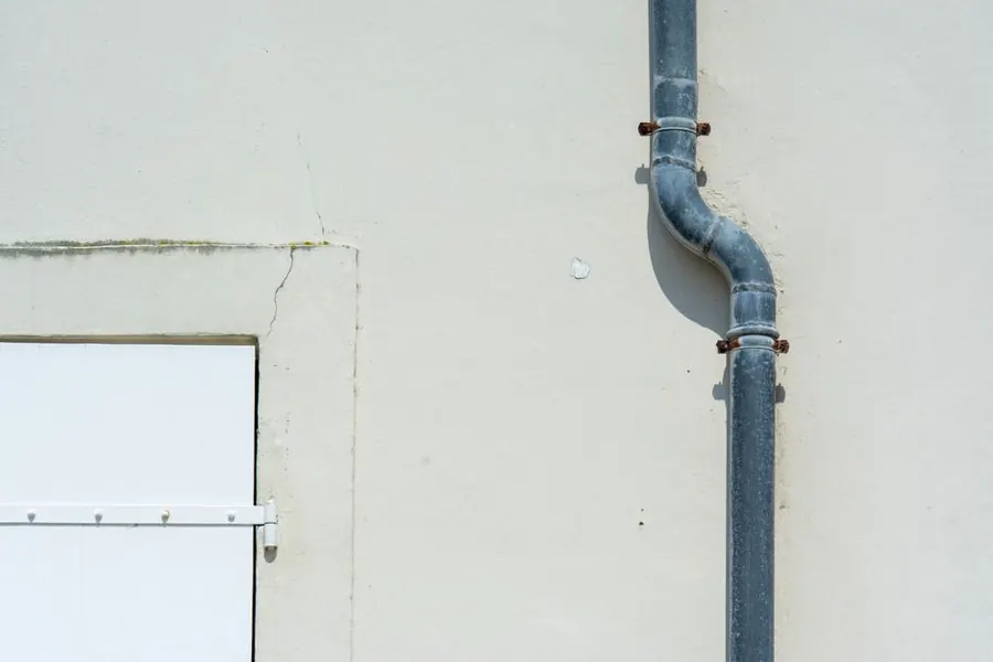 A rainwater downpipe running down a wall, where an extension flat roof has to discharge to lawful drainage in Weston-super-Mare