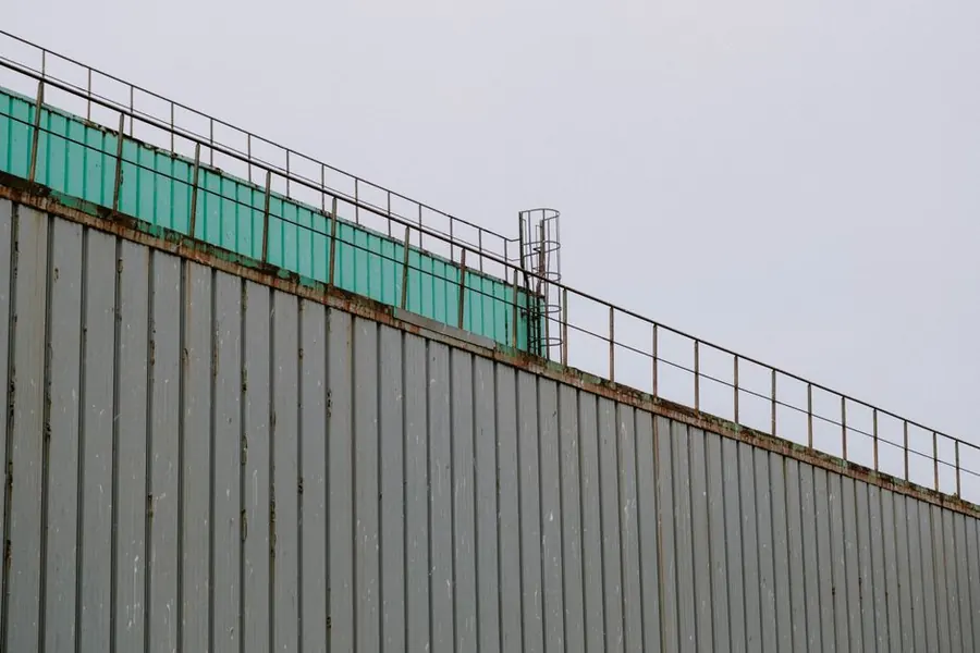 The exposed edge and parapet detail of a flat roof, where wind uplift loads are at their highest