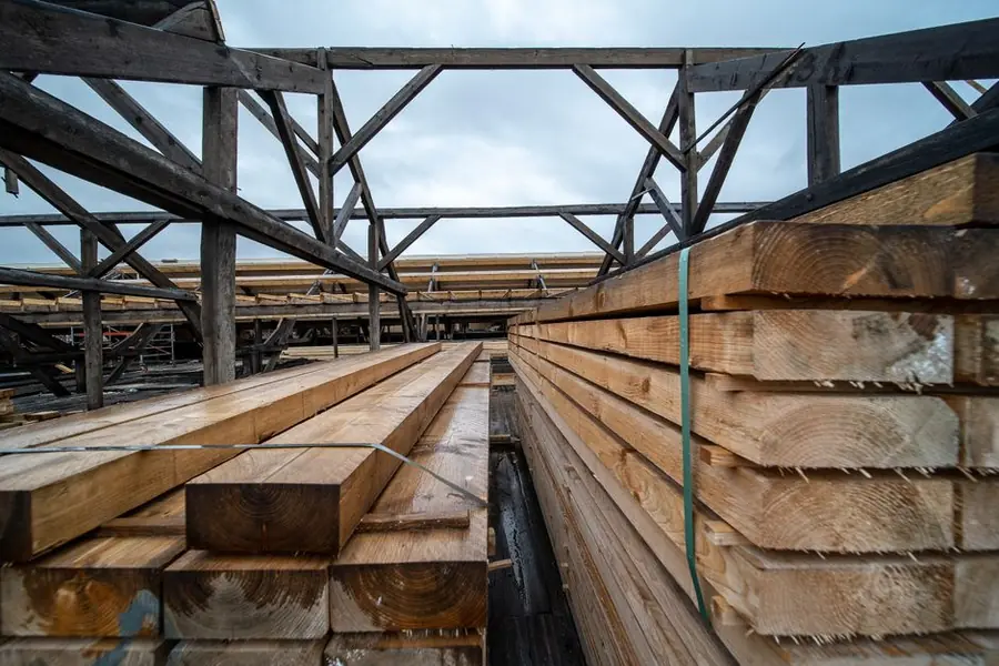 Stacked building materials in a yard under grey British skies, the supply side of flat roof insulation costs near Weston-super-Mare