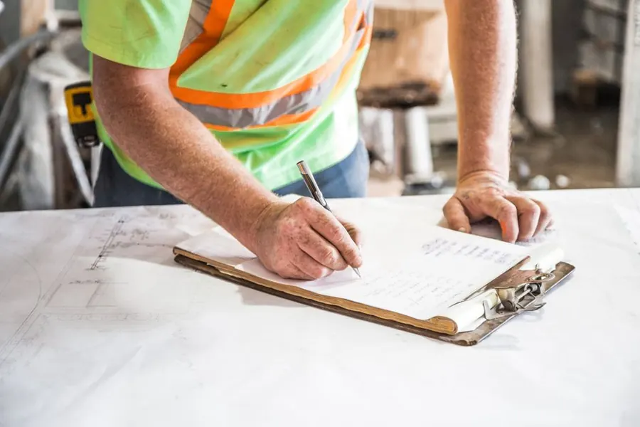 Notes being written up on site before a flat roof quote is priced in Weston-super-Mare
