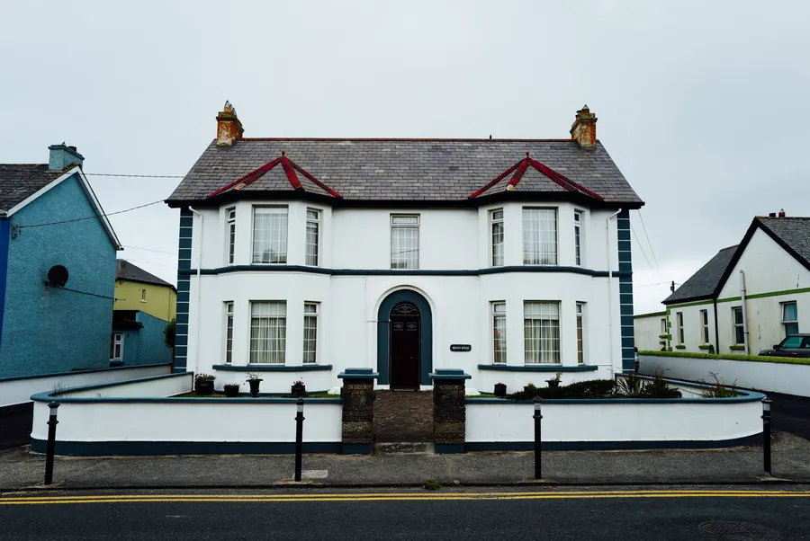 A double-fronted period house with two bay windows and rendered walls behind a low front wall, the kind of property where flat roof costs in Clevedon depend on access