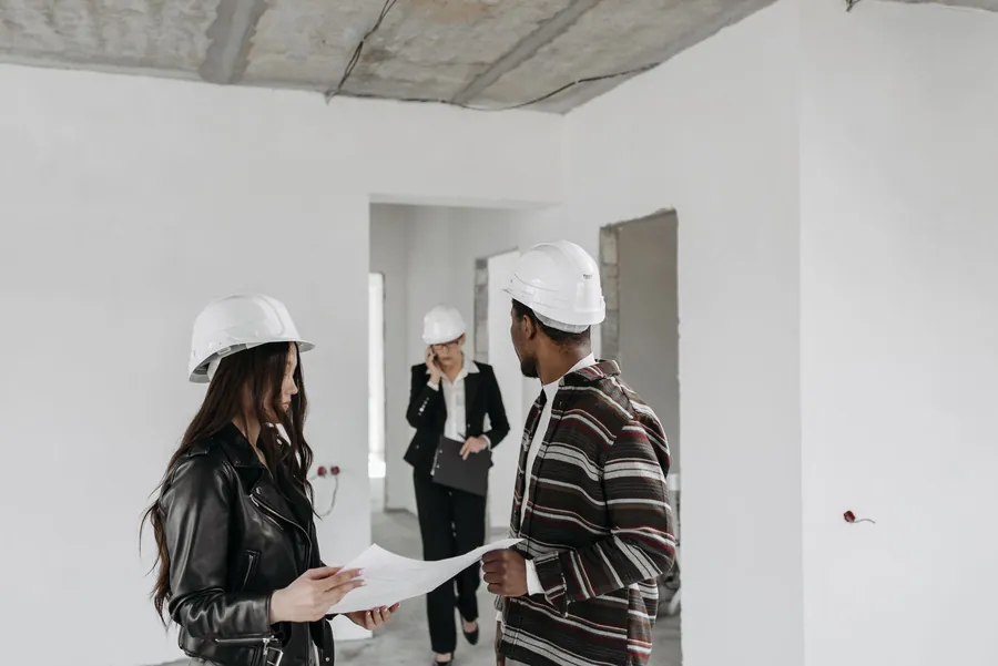 Two trades discussing drawings on site, the conversation that decides who is liable for a flat roof leak under a solar array