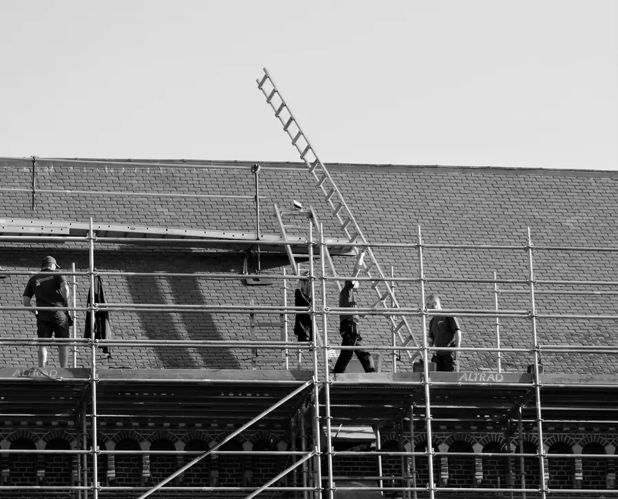 Roofers working from a scaffold with a ladder to the upper roof, the type of access needed for dormer roof work in Weston-super-Mare
