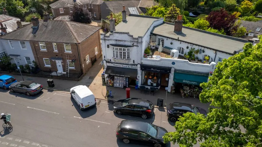 A parade of shops with flat roofs above, the kind of small commercial roof replaced around Weston-super-Mare