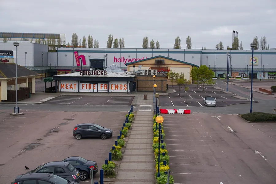 Large commercial buildings with flat roofs on a UK retail park, the kind of area suited to single ply membrane