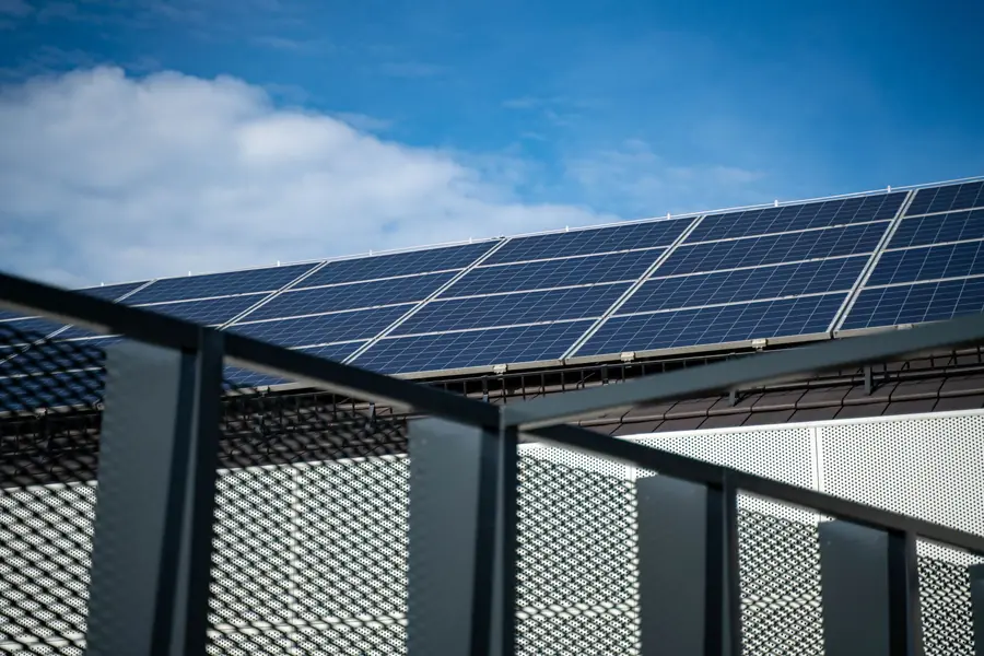 A tilted solar panel frame at a flat roof edge with guarding, showing how the array is fixed and protected on a Weston-super-Mare roof