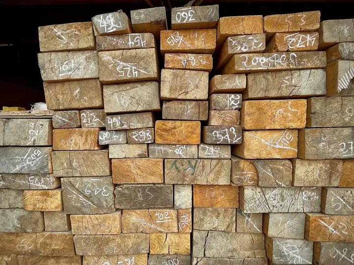End grain of stacked softwood timbers marked with chalk measurements, the joists and deck timber that decide the cost of a flat roof in Nailsea or Portishead