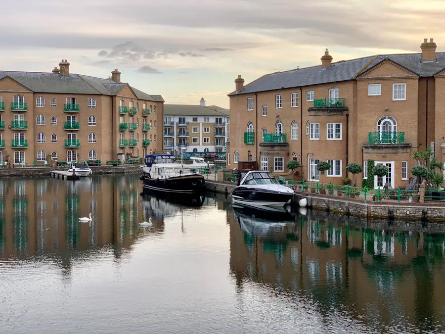 Brick apartment buildings with small balconies overlooking a marina basin at dusk, similar to the waterfront blocks around Portishead marina