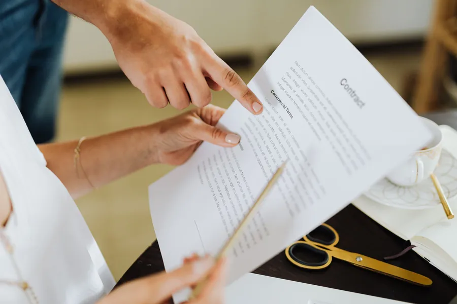 Two people reviewing the commercial terms of a contract, the written agreement needed between roofer and solar installer in Weston-super-Mare