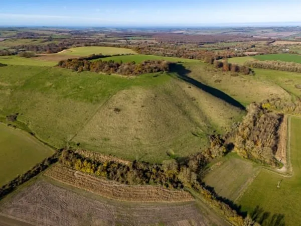 Grassy earthwork ramparts on a wooded hilltop, the Iron Age remains crowning Cadbury Hill at Congresbury