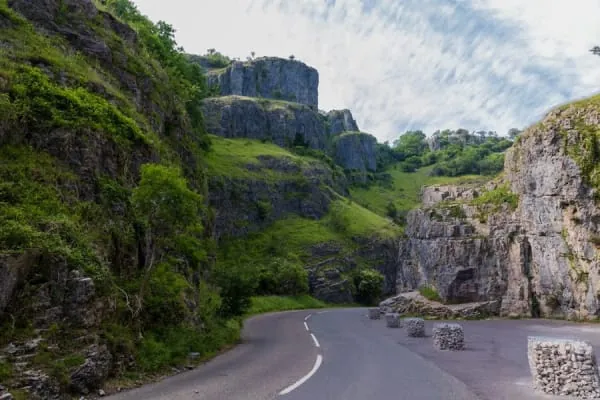 Towering limestone cliffs above a winding gorge road, the dramatic scale of Cheddar Gorge