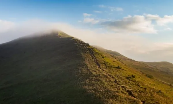 A grassy ridge catching low sunlight, the kind of summit walking Crook Peak crowns above Winscombe