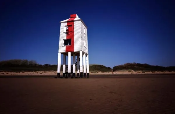 A white wooden lighthouse standing on legs on the beach, Burnham-on-Sea's famous Low Lighthouse