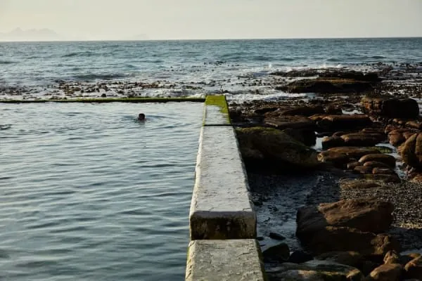 Swimmers in a broad seawater tidal pool, the open-water swimming Clevedon's Marine Lake is loved for