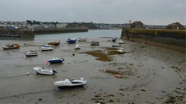 Small boats settled on the mud at low water, the tidal rhythm of Uphill's boatyard on the River Axe