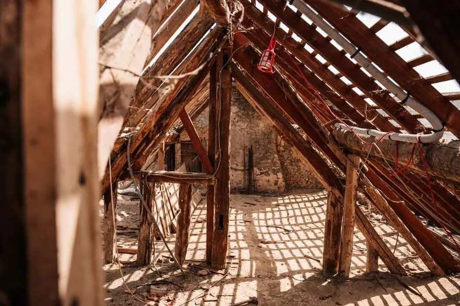 Timber joists inside a flat roof void, the route water travels before it appears on a ceiling in Weston-super-Mare